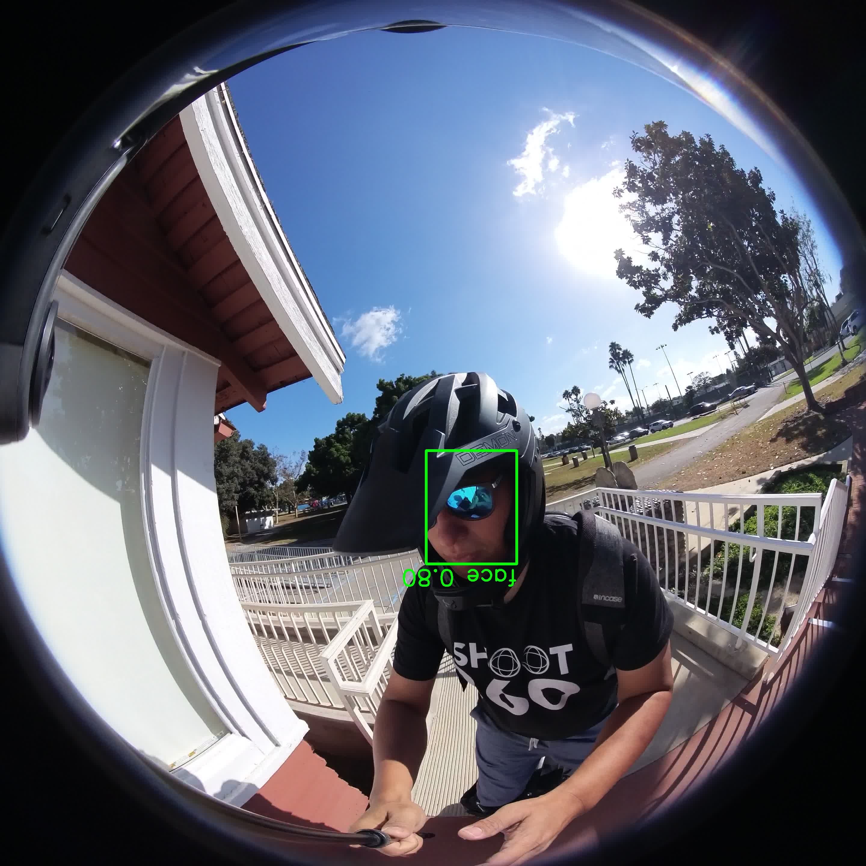 A first-person video frame with a green bounding box labelled face 0.80 around the subject’s face, showing the detection stage.